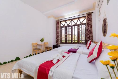 a bedroom with a large bed with red and white pillows at Villas Hồ Bơi HM Bãi Sau Thoáng Mát Sân BBQ in Vung Tau