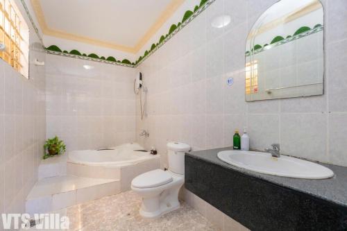 a bathroom with a toilet and a sink and a tub at Villas Hồ Bơi HM Bãi Sau Thoáng Mát Sân BBQ in Vung Tau