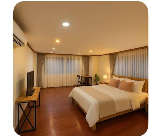 a bedroom with a large bed and a television at Omalaya Bangkok in Samphanthawong