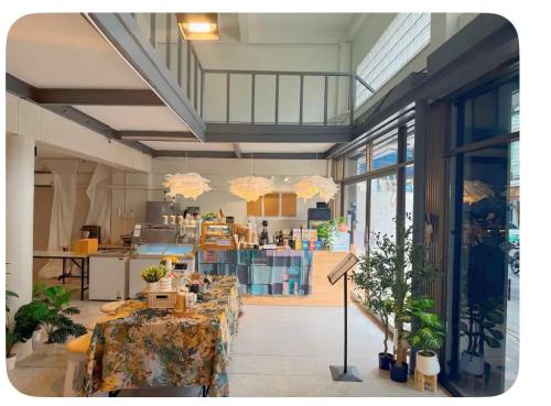 a room with two tables and a kitchen with windows at Omalaya Bangkok in Samphanthawong