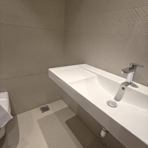 a white bathroom with a sink and a toilet at Bluestone Prime by The Cosy Hotels in New Delhi