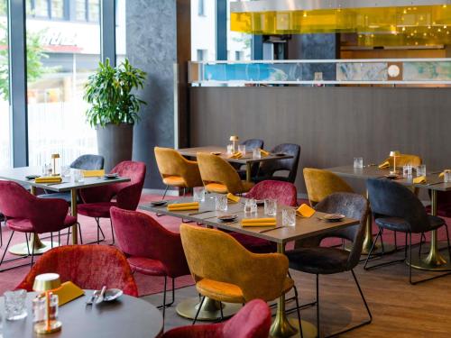 a row of tables and chairs in a restaurant at Novotel Aachen City in Aachen