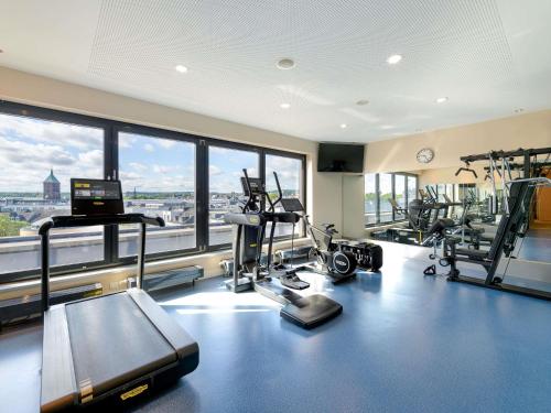 a gym with cardio equipment and a large window at Novotel Aachen City in Aachen