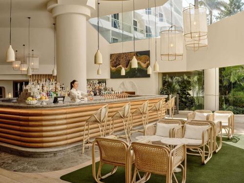 Una donna in piedi in un bar in un hotel di The Brighton Hotel Sydney - Mgallery Collection a Sydney