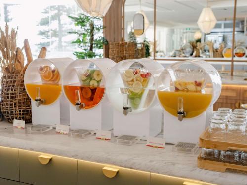 シドニーにあるThe Brighton Hotel Sydney - Mgallery Collectionのカウンターに3杯の料理を並べたビュッフェ