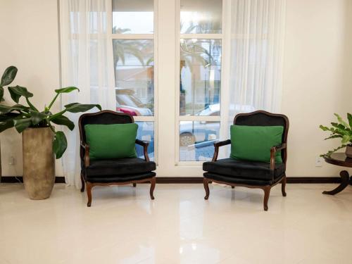 two chairs sitting in a room with a window at Mercure Jaragua do Sul in Jaraguá do Sul