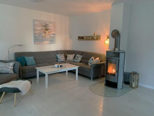 een woonkamer met een bank en een houtkachel bij Landhaus Scholz in Dollerup