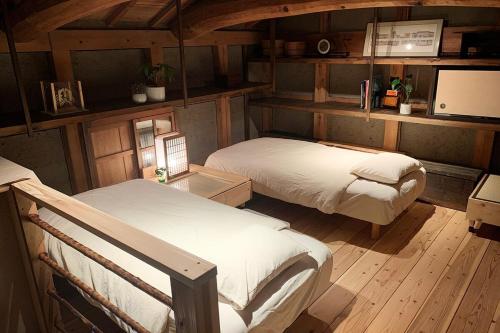 長浜市にあるオハナの木製の床の部屋にベッドが2つあります
