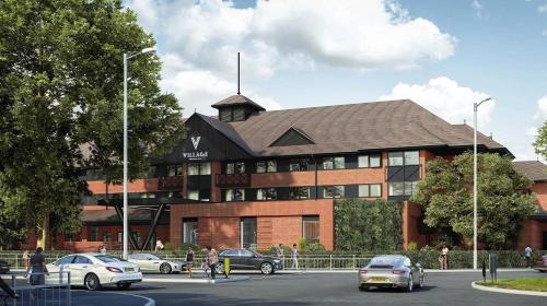 a large building with cars parked in front of it at Village Hotel Reading in Reading