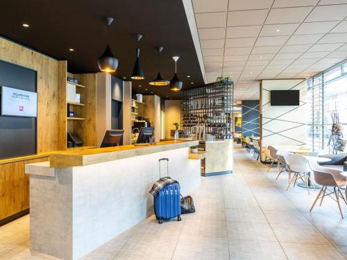 a bar in a restaurant with a blue suitcase at ibis Hotel Hamburg St. Pauli Messe in Hamburg