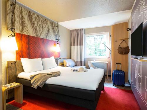 a hotel room with a large bed and a window at ibis Hotel Hamburg St. Pauli Messe in Hamburg