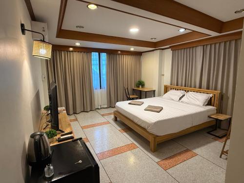 a bedroom with a bed and a television in it at Omalaya Bangkok in Samphanthawong