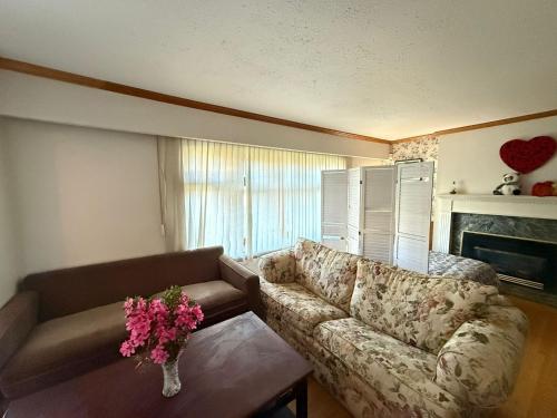 a living room with a couch and a table with flowers at Downtown Central City Cozy Private 2 Bedroom Basement Suite - Independent Entry in Surrey
