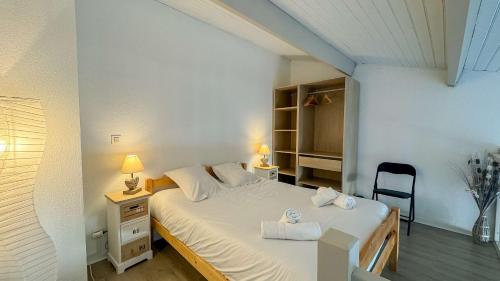 a bedroom with a bed with two towels on it at Jolie maison à étage en résidence avec piscine in Saint-Martin-de-Ré