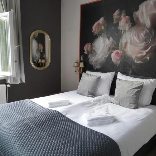 a bedroom with a bed with a painting on the wall at Villa Burgau in Monschau