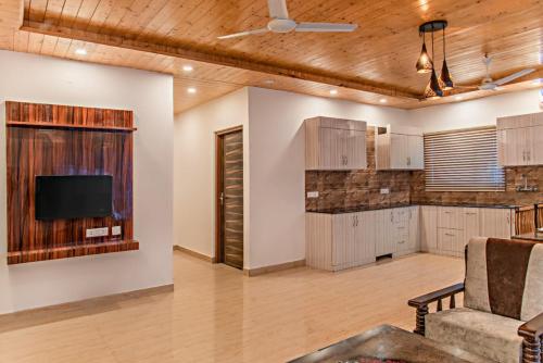 a living room with a kitchen and a tv at The Mountain Peak I Guaranteed Best Price I Vacations I Family Events I Pet friendly & Serviced Apts I Kasauli By Exotic Stays in Kasauli