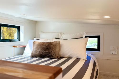 a bedroom with a bed with white sheets and pillows at Grace & Rose in Gibbston
