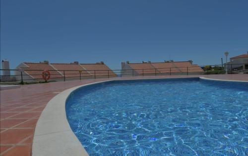 a large swimming pool on a building with chairs at Granny's House by Trip2Portugal in Carvoeira