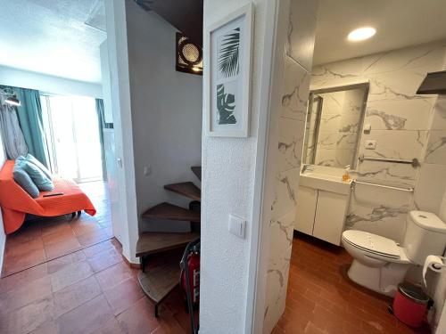 a bathroom with a toilet and a staircase in it at Amazing Sesimbra Duplex by the beach in Sesimbra
