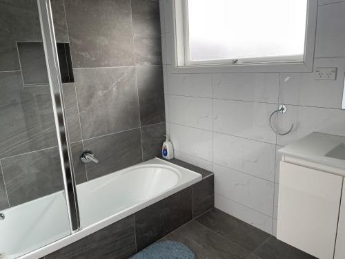a bathroom with a shower and a bath tub at Living Oasis Home in Auckland