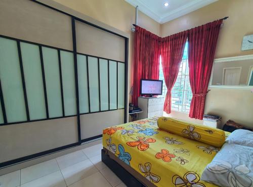 a bedroom with a bed and a window with red curtains at Feels Like Home, Right Here in Melaka! in Solok Belimbing