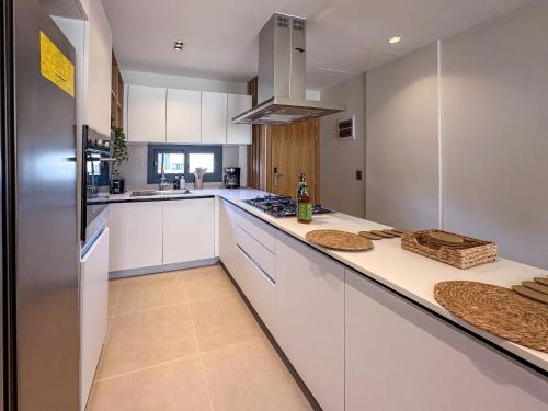 a kitchen with white cabinets and a counter top at Beautiful brand new Beach Condo w Picuzzi in Punta Cana