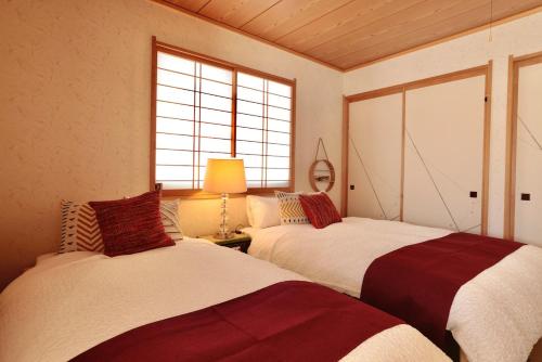 two beds in a room with two windows at Azumino salon2 in Azumino