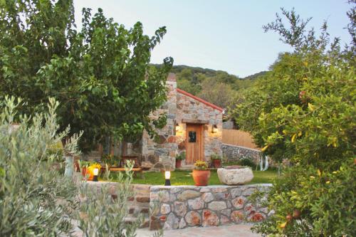 a stone house with a stone wall and a yard at Karaincirevleri in Emecik