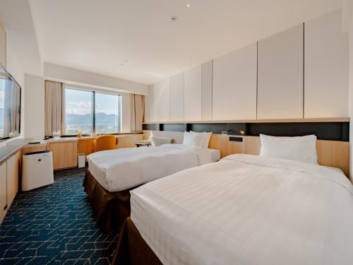 une chambre d'hôtel avec deux lits et une télévision dans l'établissement Keio Prelia Hotel Sapporo, à Sapporo