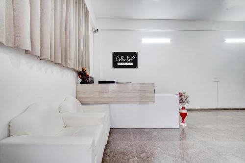 a living room with a white couch and a table at Collection O Sector 7 Rohini Formerly Giriraj Residency in New Delhi