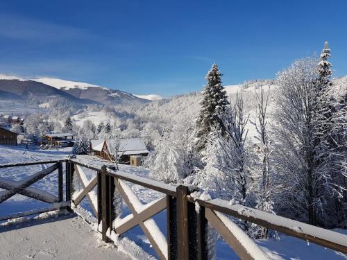a snow covered mountain with trees and a fence at Shatiz in Izki