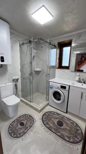 a bathroom with a shower and a washing machine at Садиба Кичера Еко in Mizhhirya