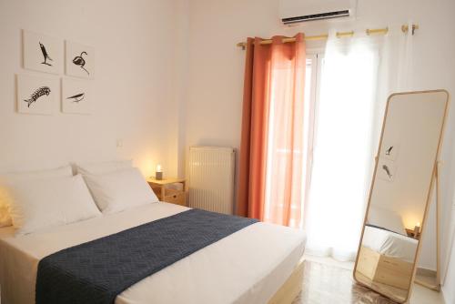 a bedroom with a bed and a mirror and a window at Down Town Sitia i in Sitia
