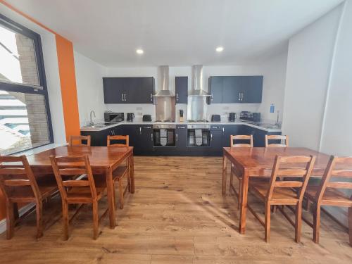 a dining room with a table and chairs and a kitchen at Hullywood rooms with shared kitchen facilities in Hull