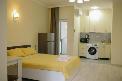un salon avec un lit et une cuisine dans l'établissement Batumi city apartments, à Batoumi