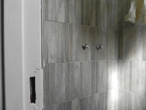 y baño con ducha y paredes de madera. en Sensations Lodge Highlands, en Johannesburgo
