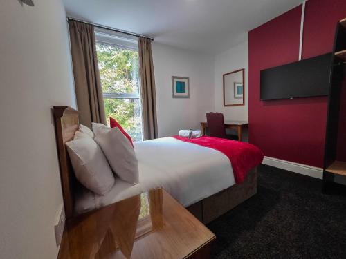 a hotel room with a bed and a window at Hullywood rooms with shared kitchen facilities in Hull