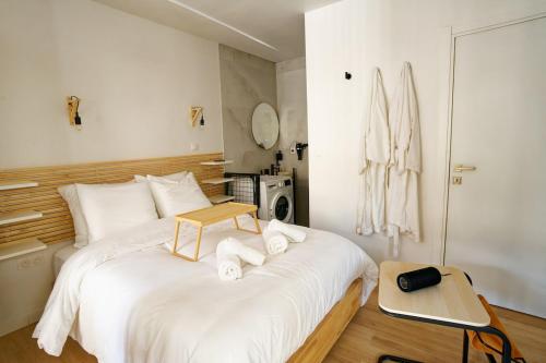 a bedroom with a bed with towels on it at Wake up in white - Private Jacuzzi & cotton comfort in Verdun