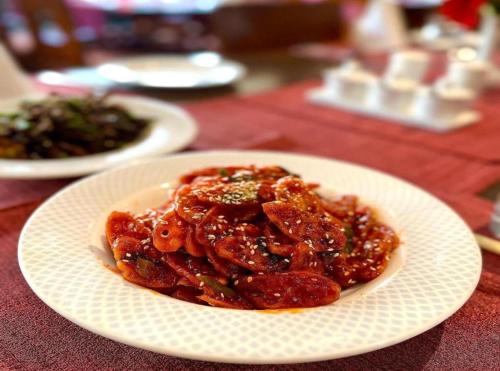 a white plate of food on a table at Hotel The Grand Olive Aero Suites Near Delhi Airport in New Delhi
