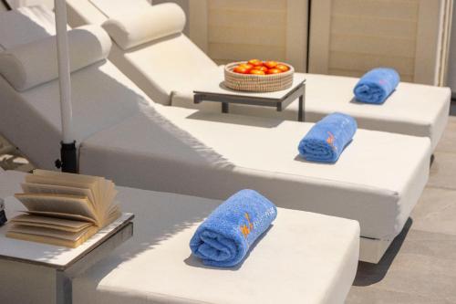 three beds in a room with blue towels on them at Nissini villa in Ayia Napa