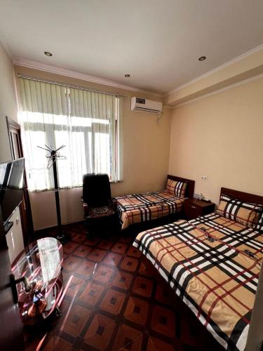 een hotelkamer met twee bedden en een raam bij Tatev in Jerevan