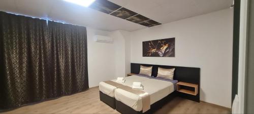 a bedroom with a bed and a black curtain at Хостел Цанови in Pleven