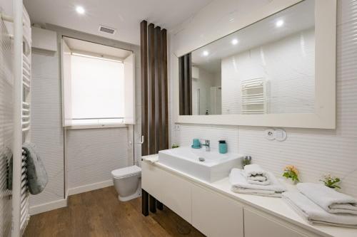 a white bathroom with a sink and a mirror at Casa da Ladeira by Trip2Portugal in Figueira da Foz