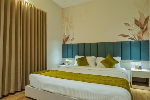 a bedroom with a large bed with a blue headboard at M Suites And Hotel in Cochin