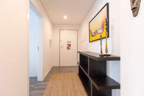 a hallway with a black desk and a painting on the wall at Comfort & Style w/ best sea view in Sesimbra