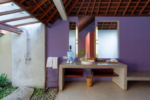 a bathroom with a sink and a shower at Temuku Ubud Villas in Ubud