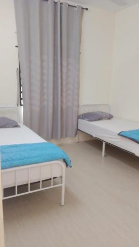 a bedroom with two beds and a curtain at Homestay Bajet Kg Telaga Mas Paka in Paka
