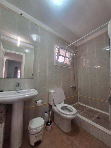 a bathroom with a toilet and a sink and a mirror at Casa vista golf in Caleta De Fuste
