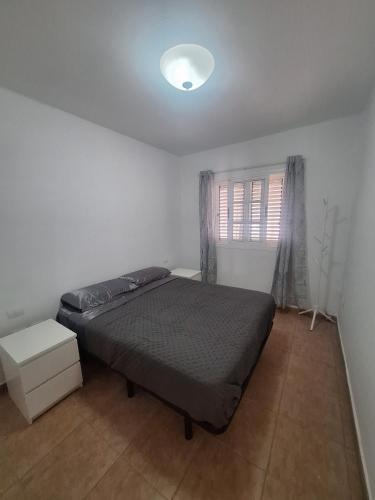 a bedroom with a bed and a window at Casa vista golf in Caleta De Fuste