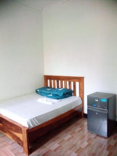 a small bedroom with a bed and a television at Banana Grove Retreat in Moshi